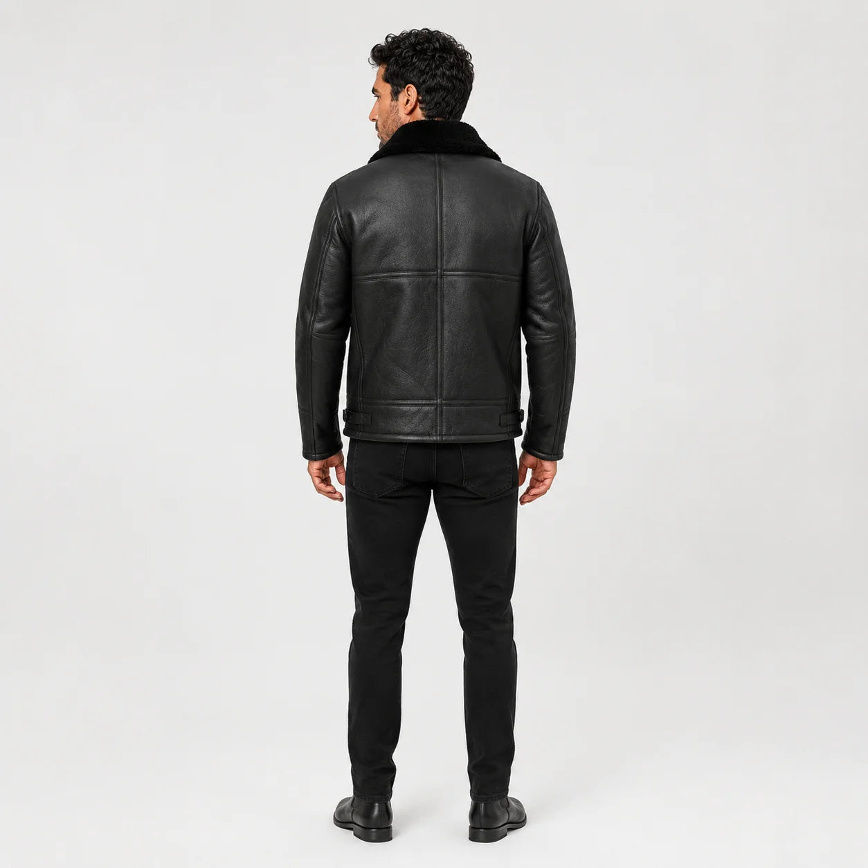 Rear model view of black aviator jacket showing panelled back construction, plush collar and waist adjustment tabs