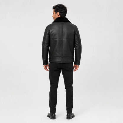 Rear model view of black aviator jacket showing panelled back construction, plush collar and waist adjustment tabs