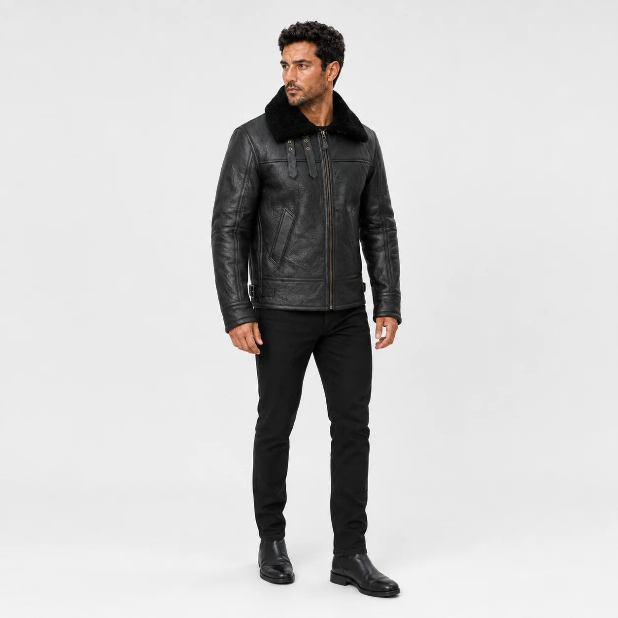 Three-quarter studio view of men’s black flight jacket highlighting plush collar, throat straps and structured fit