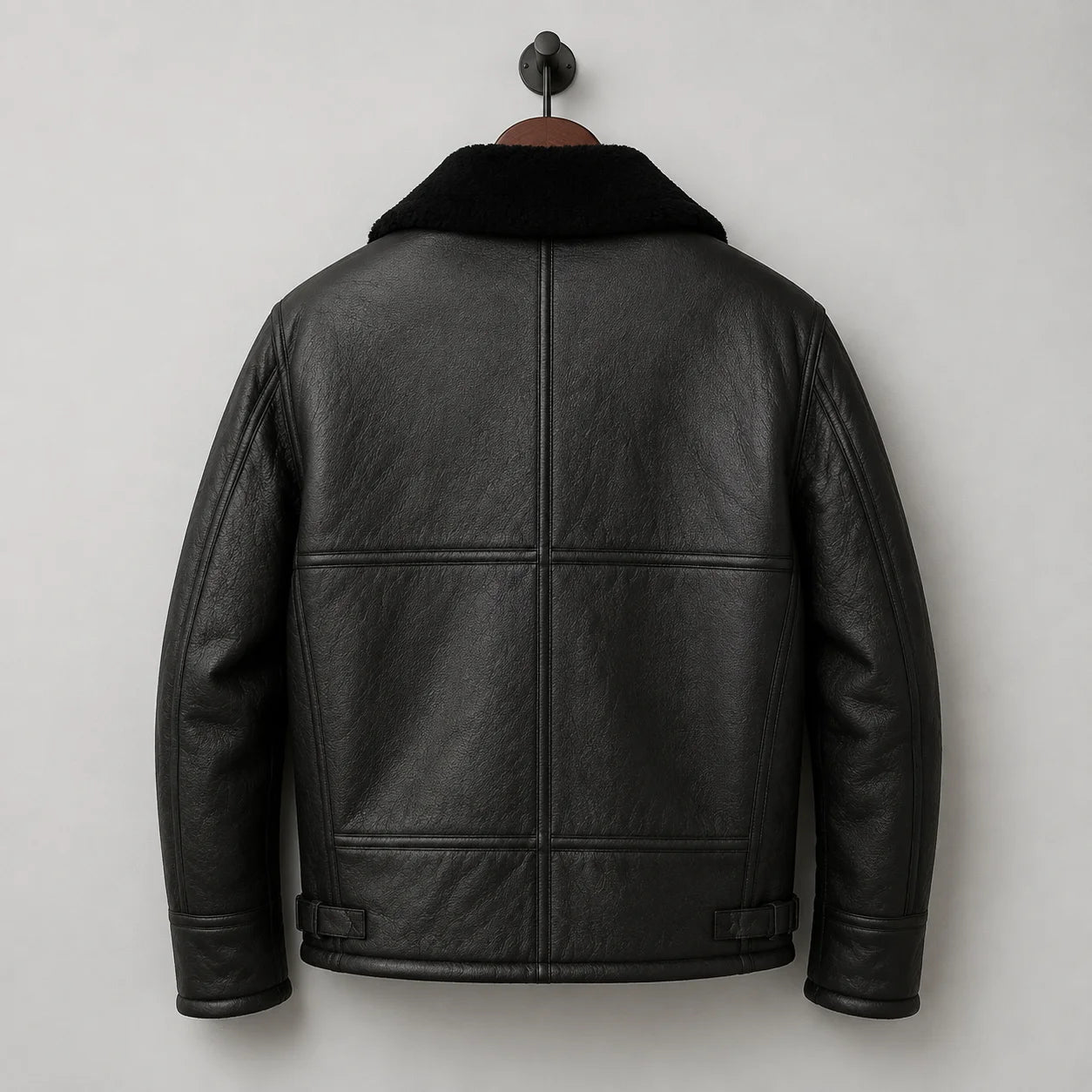Hanging back view of black aviator jacket showing horizontal panels, centre back seam and adjustable waist details