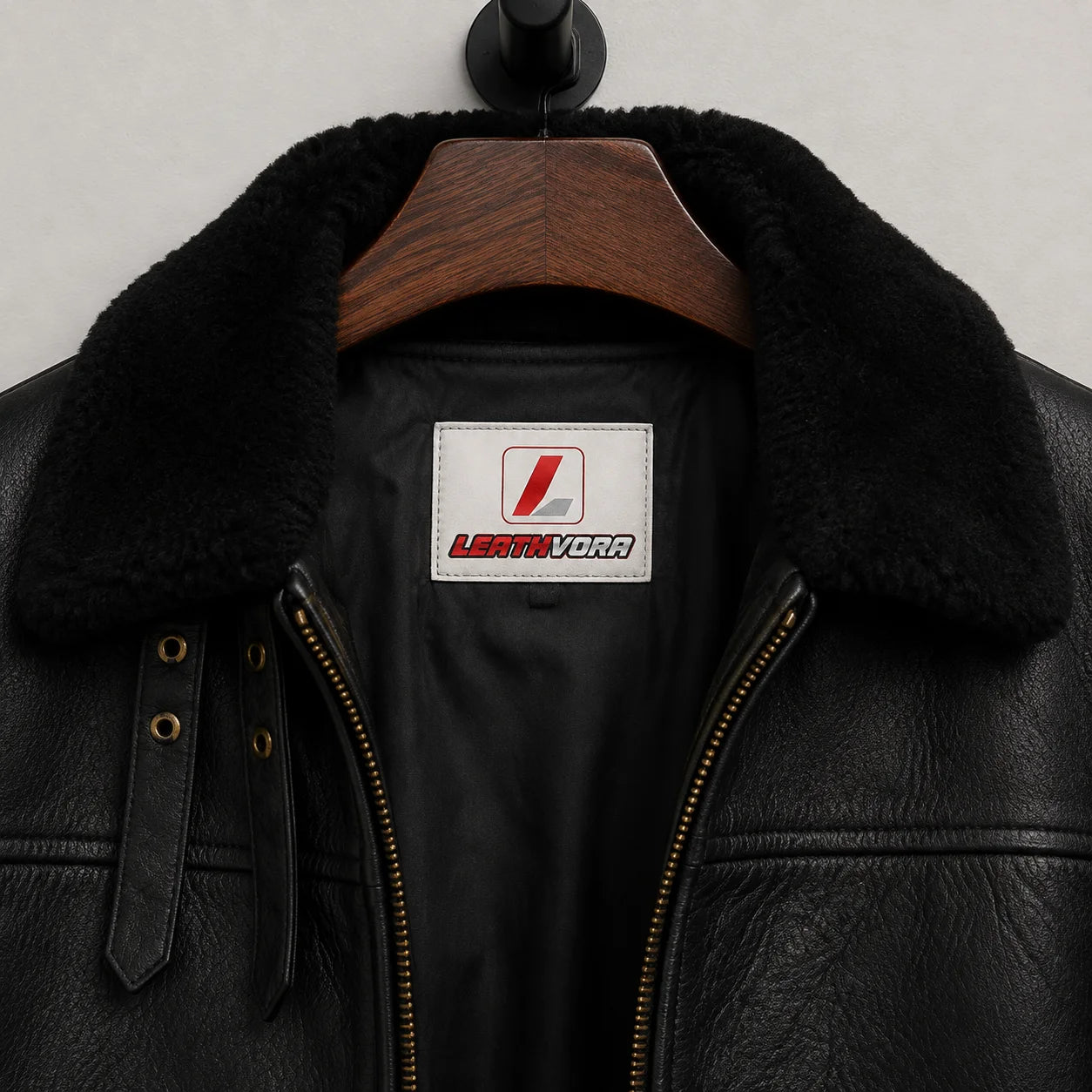 Close-up of plush black aviator collar, throat straps, zip teeth, textured outer finish and Leathvora branding
