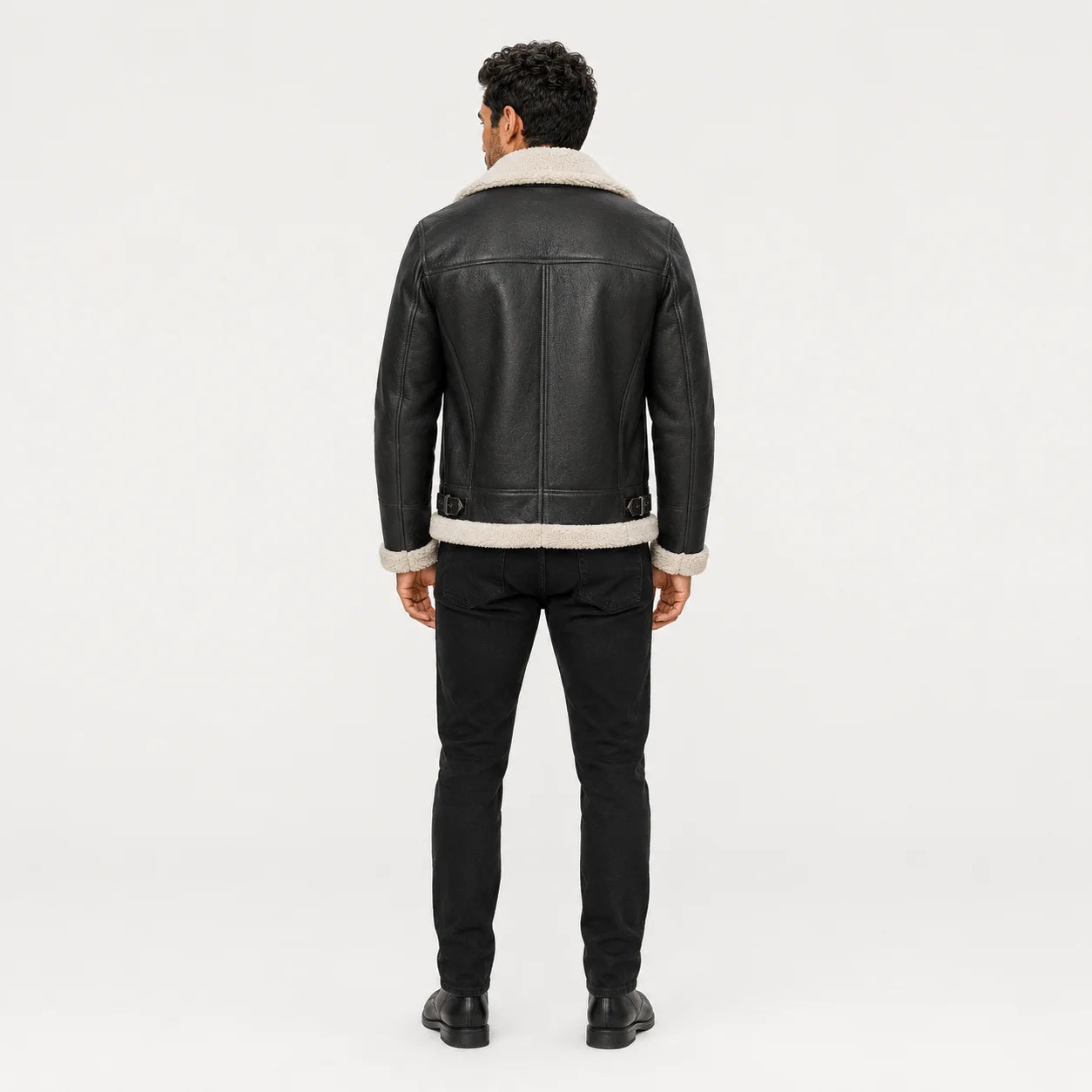 Rear model view of black aviator jacket showing white collar and hem trim, panelled back and waist buckle details