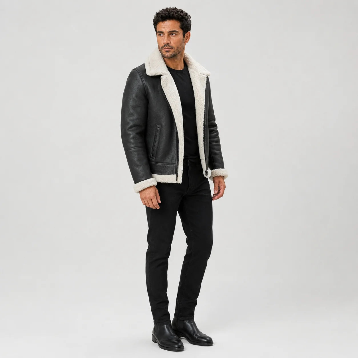 Three-quarter studio view of men’s black flight jacket highlighting white plush lapels, cuffs and side pocket