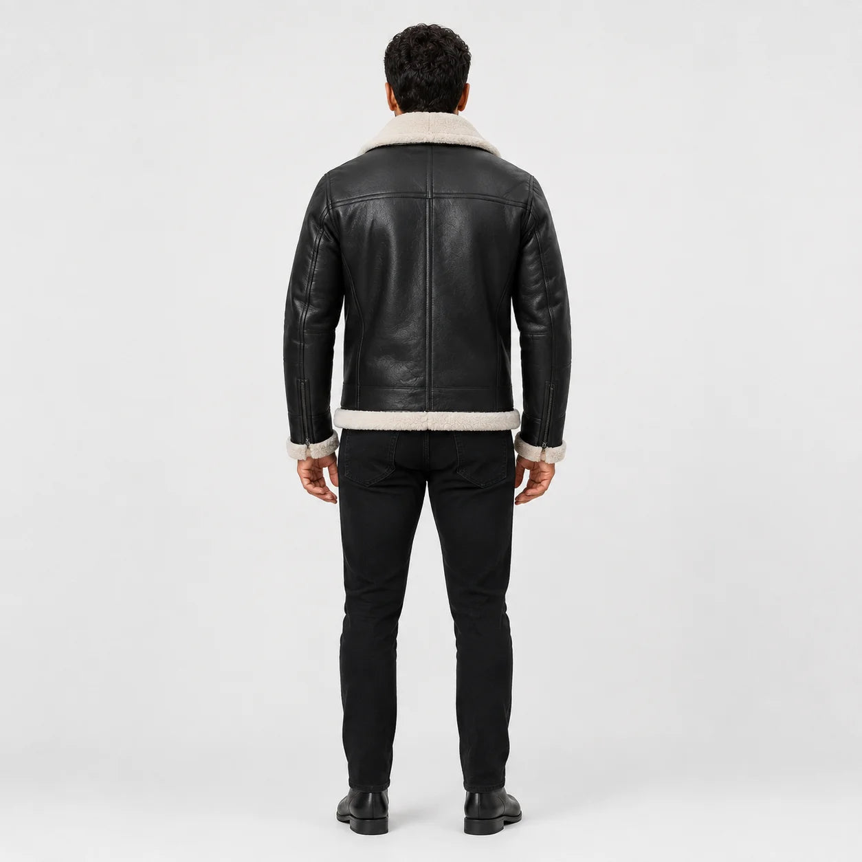 Rear model view of dark aviator leather jacket showing cream collar, structured back panels and fur-trimmed hem