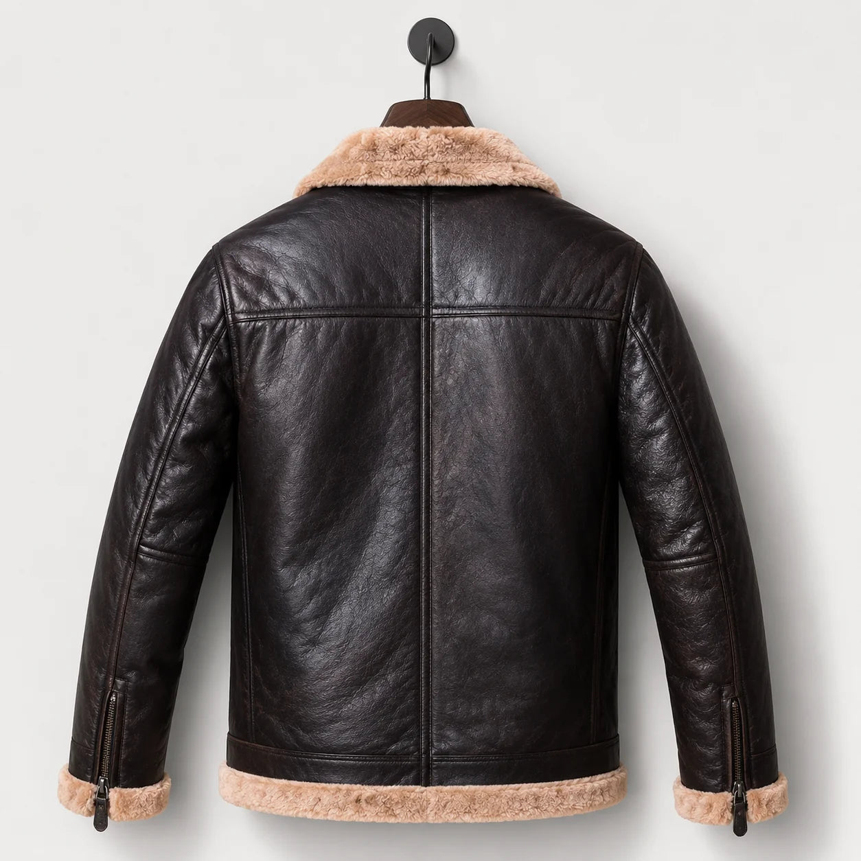 Hanging rear view showing dark leather back, centre seam, shoulder yoke, cream collar and fur-trimmed hem