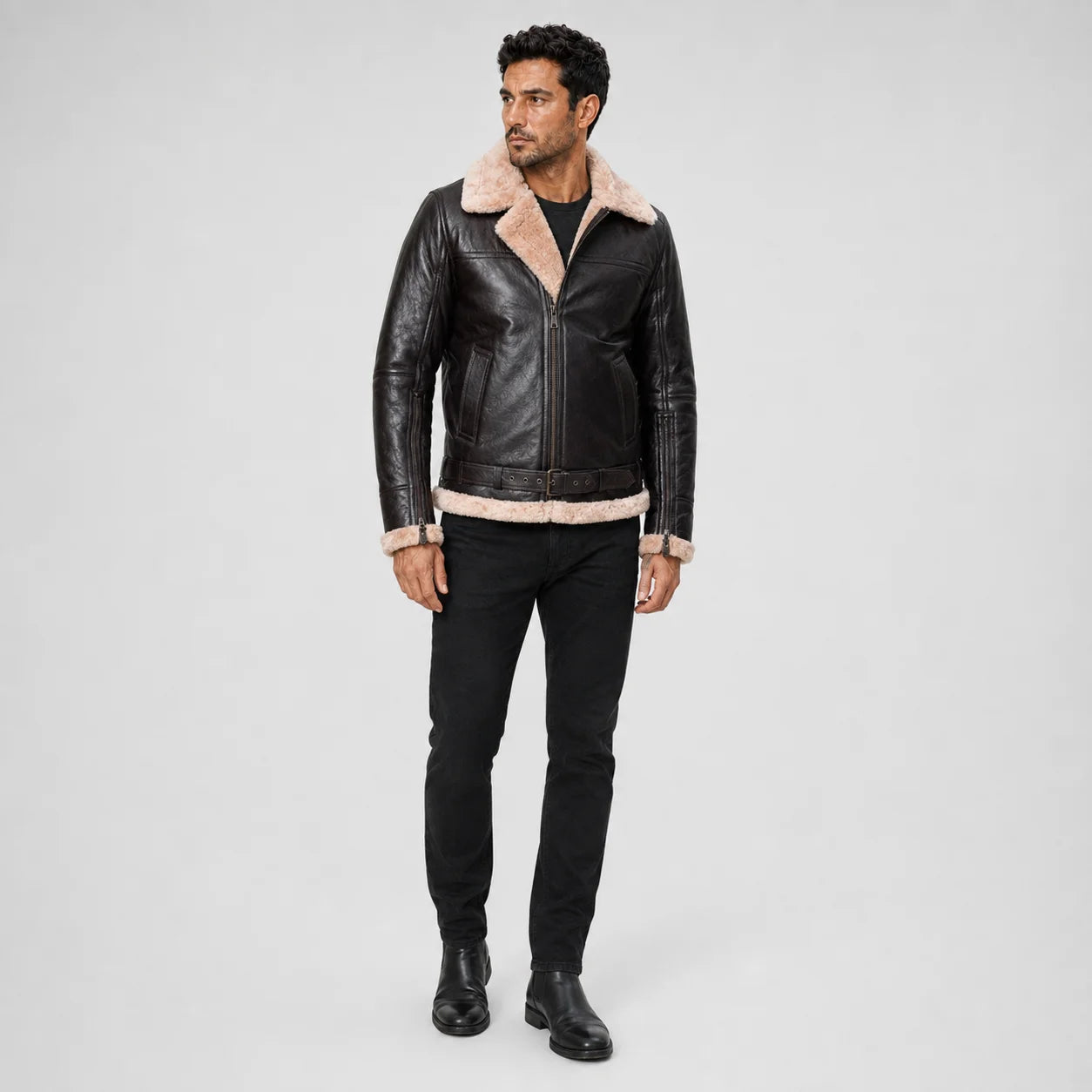 Full-length studio model view of dark leather flight jacket with cream fur trim, zip front and waist buckle