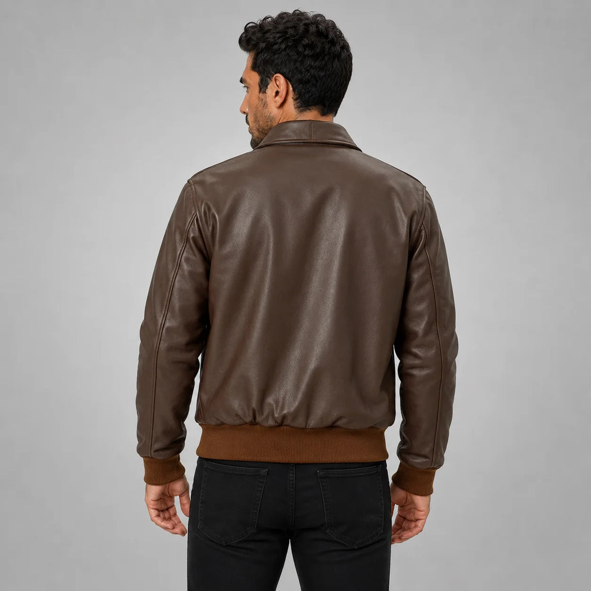 Rear model view of men’s brown leather flight jacket with structured shoulders and contrasting knitted waist