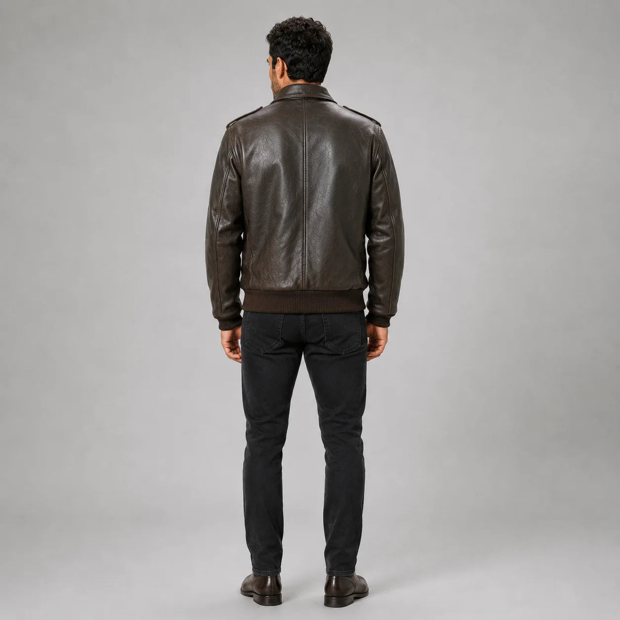 Rear model view showing brown leather flight jacket centre-back seam, shoulder epaulettes and ribbed waist