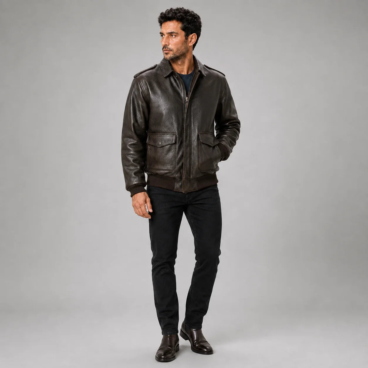Three-quarter studio view of men’s brown leather bomber jacket with zip front and aviation-inspired details