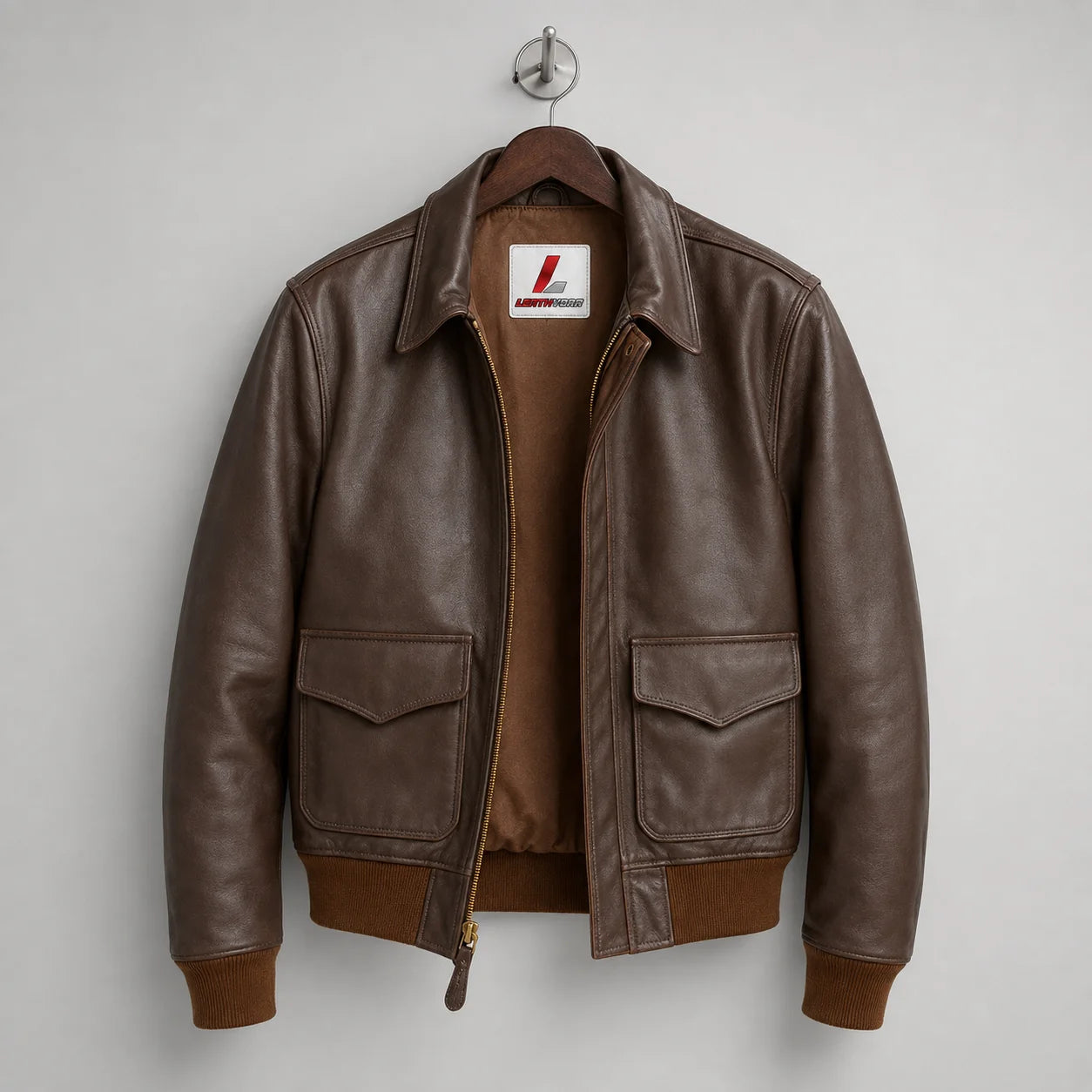 Front hanger view of brown leather aviator jacket with fold-down collar, zip front and two flap pockets