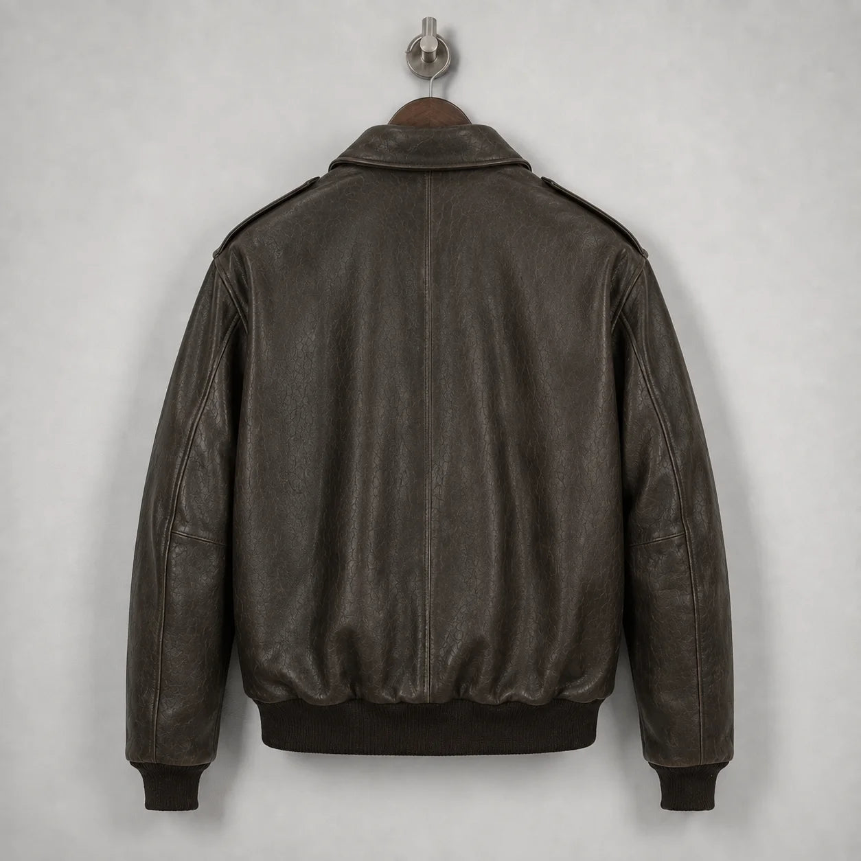 Close-up of brown leather flight jacket collar with beige map-print lining and Leathvora branding