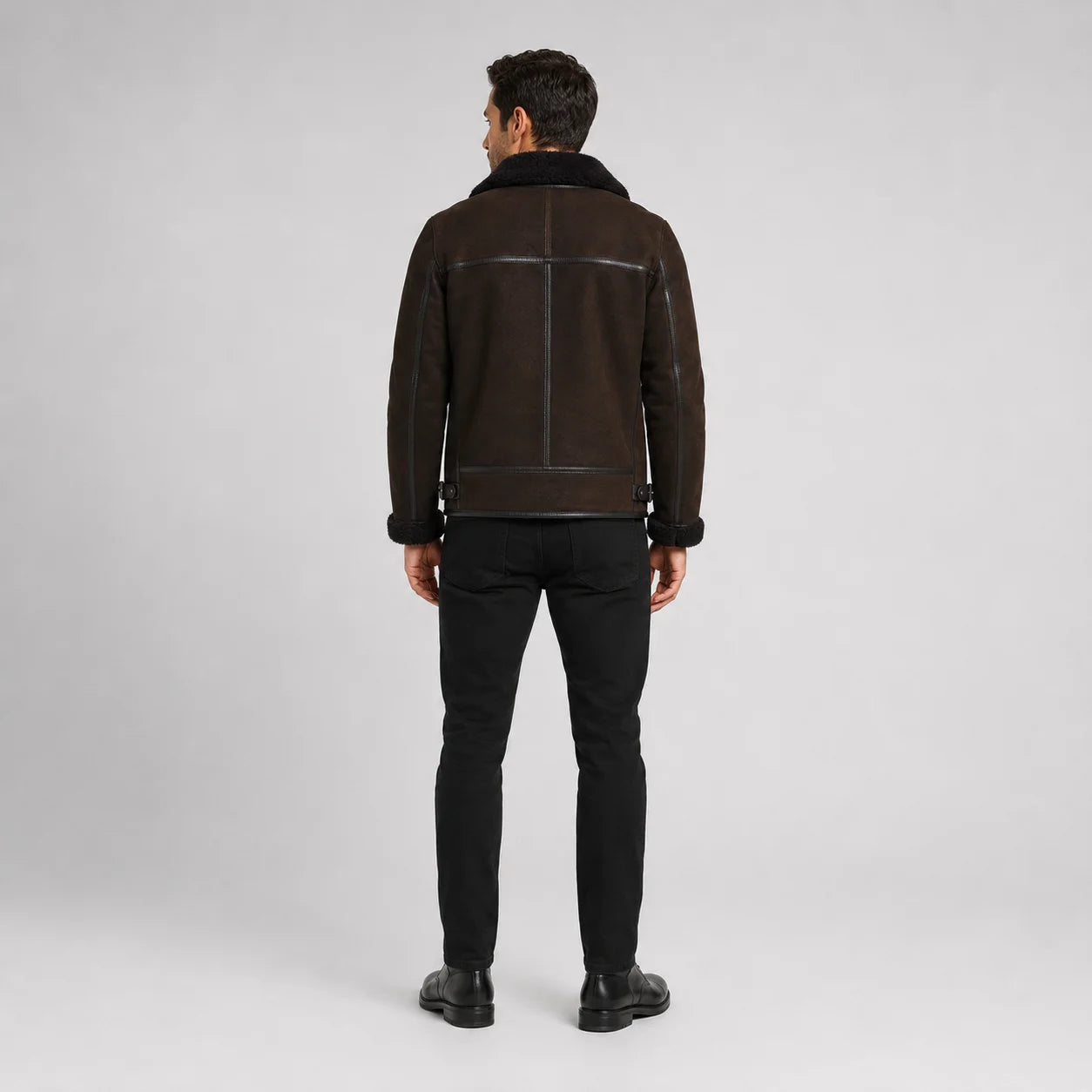 Rear studio view showing brown aviator jacket back yoke, centre seam, black trim and waist adjustment tabs