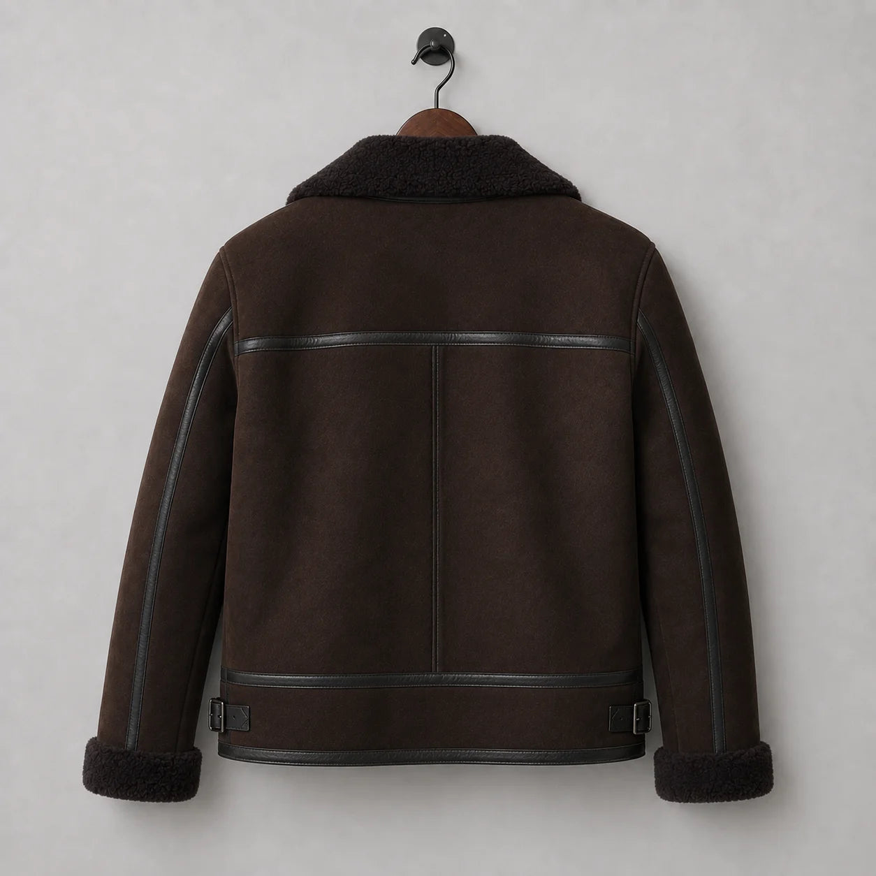 Hanging rear view of brown aviator jacket showing horizontal shoulder trim, central seam and buckle waist tabs