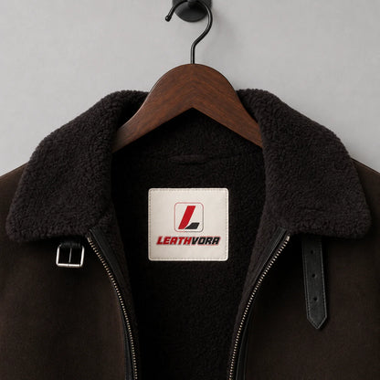Close-up of black plush aviator collar, dark brown exterior, zipper, buckle straps and Leathvora neck label