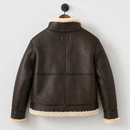 Hanging rear view of men’s brown leather B3 jacket showing central back seam, horizontal panels and cream-trimmed hem.