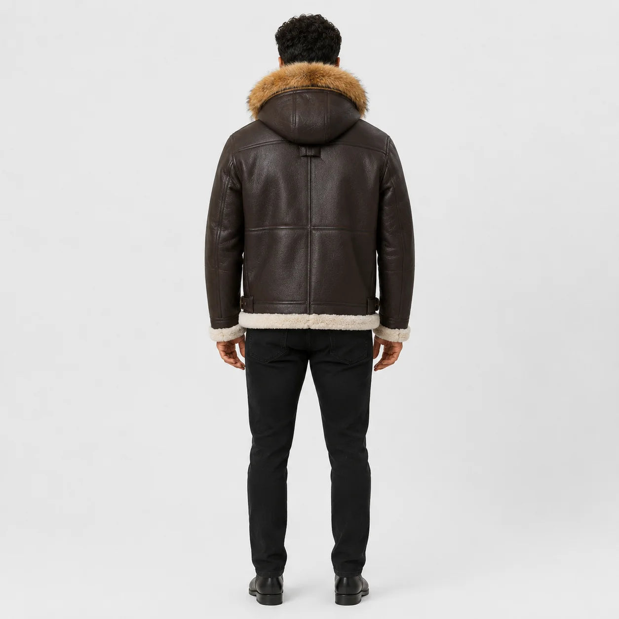 Rear full-length view of men’s brown hooded B3 jacket showing panelled leather back, fur-trim hood and shearling hem.