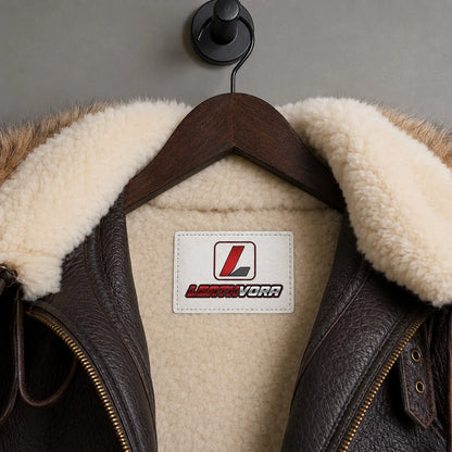 Close-up of cream shearling interior and collar on brown B3 bomber jacket with Leathvora branding patch visible.