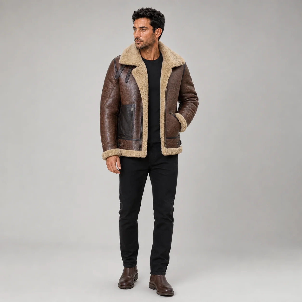 Front studio view of men’s brown B3 sheepskin aviator jacket with cream shearling collar, zip pockets and black jeans