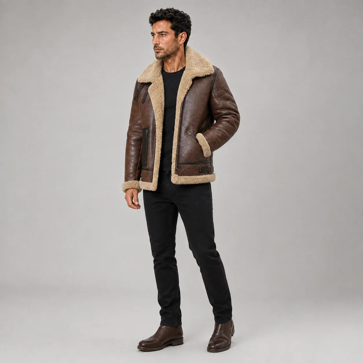 Three-quarter studio view of brown shearling aviator jacket with collar straps, angled zip pockets and cream trim