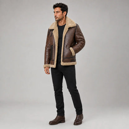 Three-quarter studio view of brown shearling aviator jacket with collar straps, angled zip pockets and cream trim