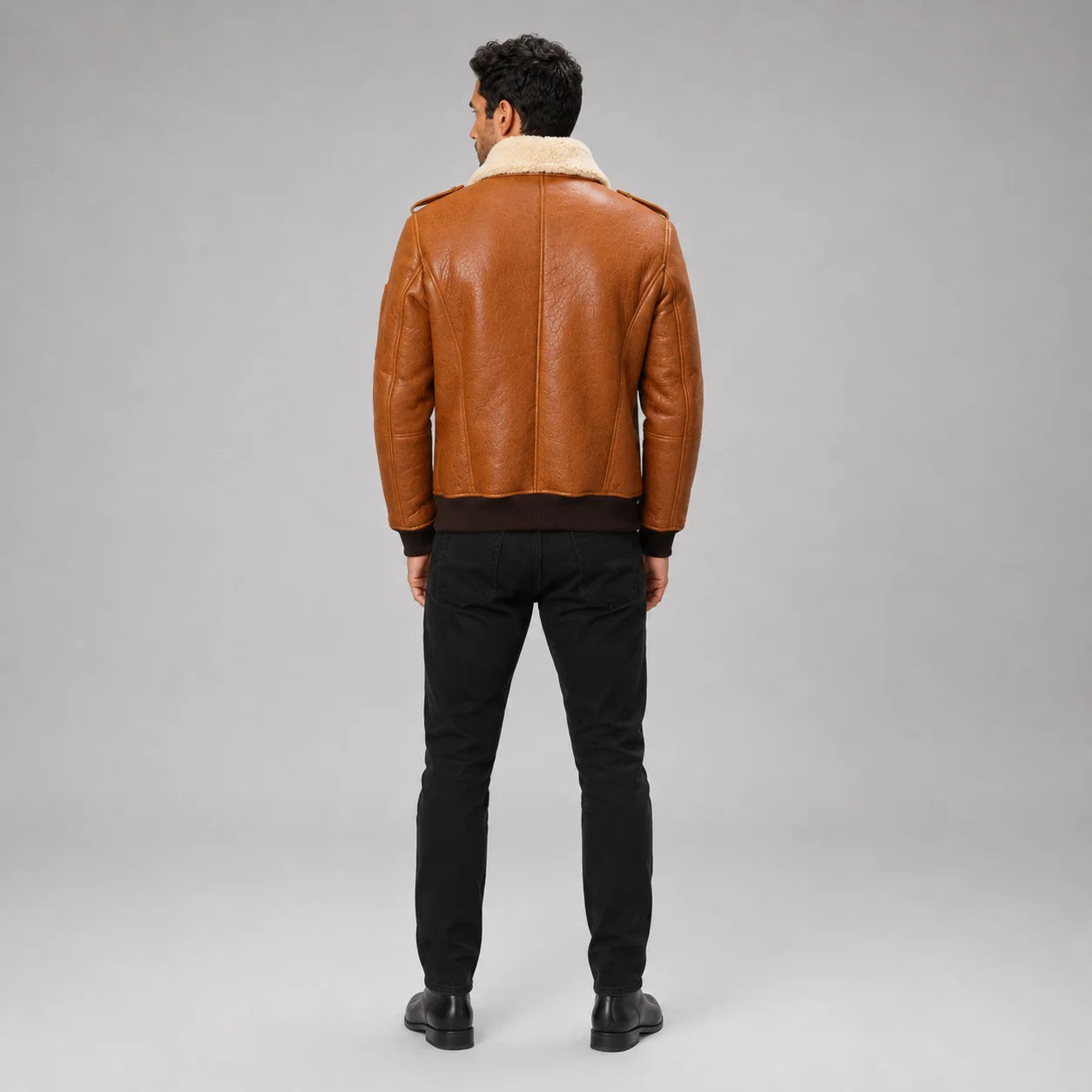 Rear studio view of brown B3 flight jacket showing clean back panels, cream collar and dark rib-knit waistband