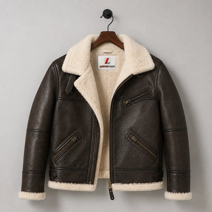 Hanging front view of brown B3 sheepskin bomber jacket showing cream lining, three zip pockets and side adjusters.
