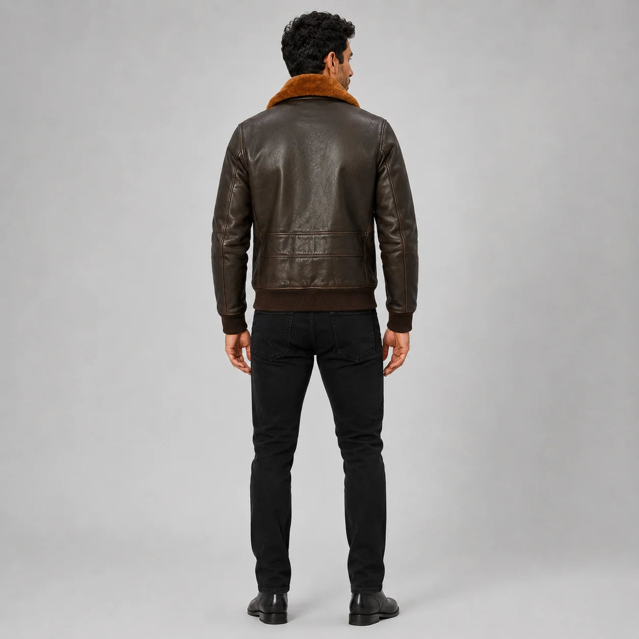 Rear model view of brown leather aviator jacket showing contrast collar, back panel and ribbed waistband