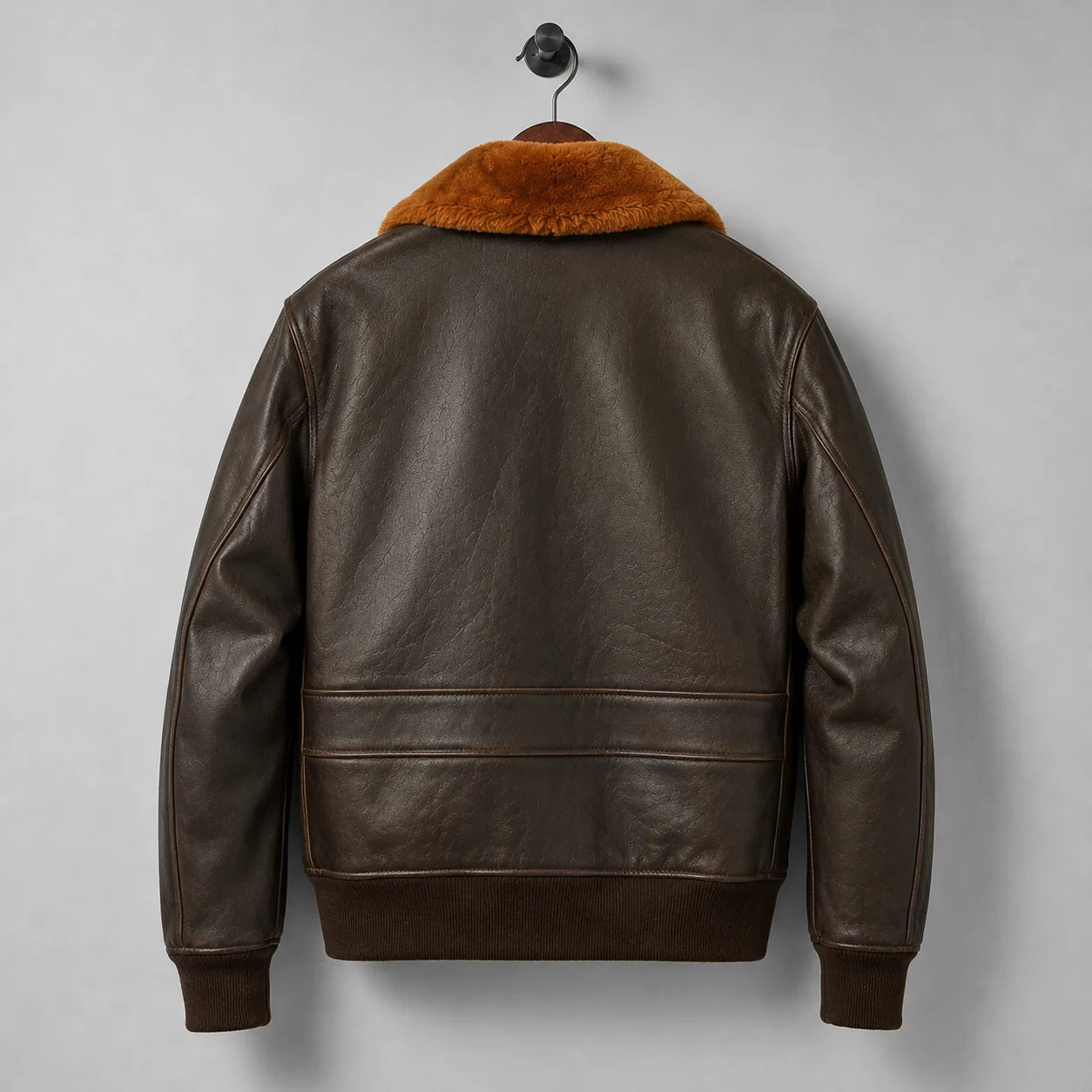 Rear product view of brown leather bomber jacket with rust collar, lower back panel and dark rib-knit waistband