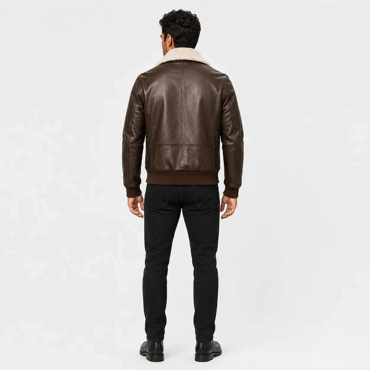 Rear model view of dark brown leather flight jacket with clean centre seam, ribbed waistband and shearling collar.
