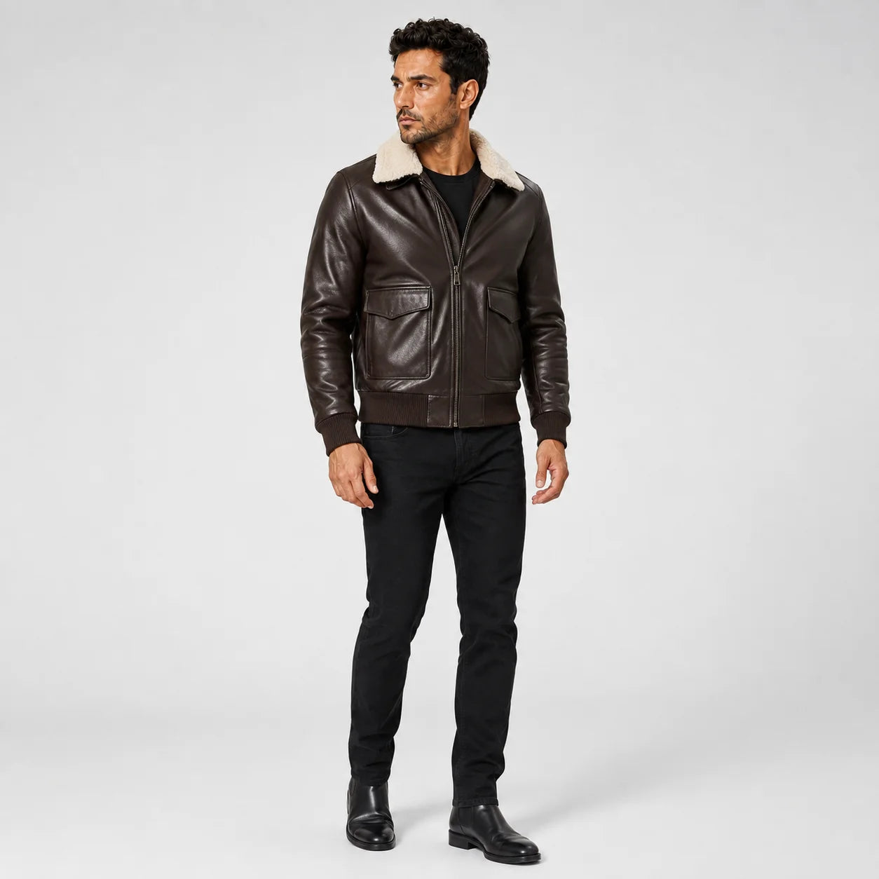 Three-quarter model view of brown lambskin bomber jacket with cream shearling collar and utility flap pockets.
