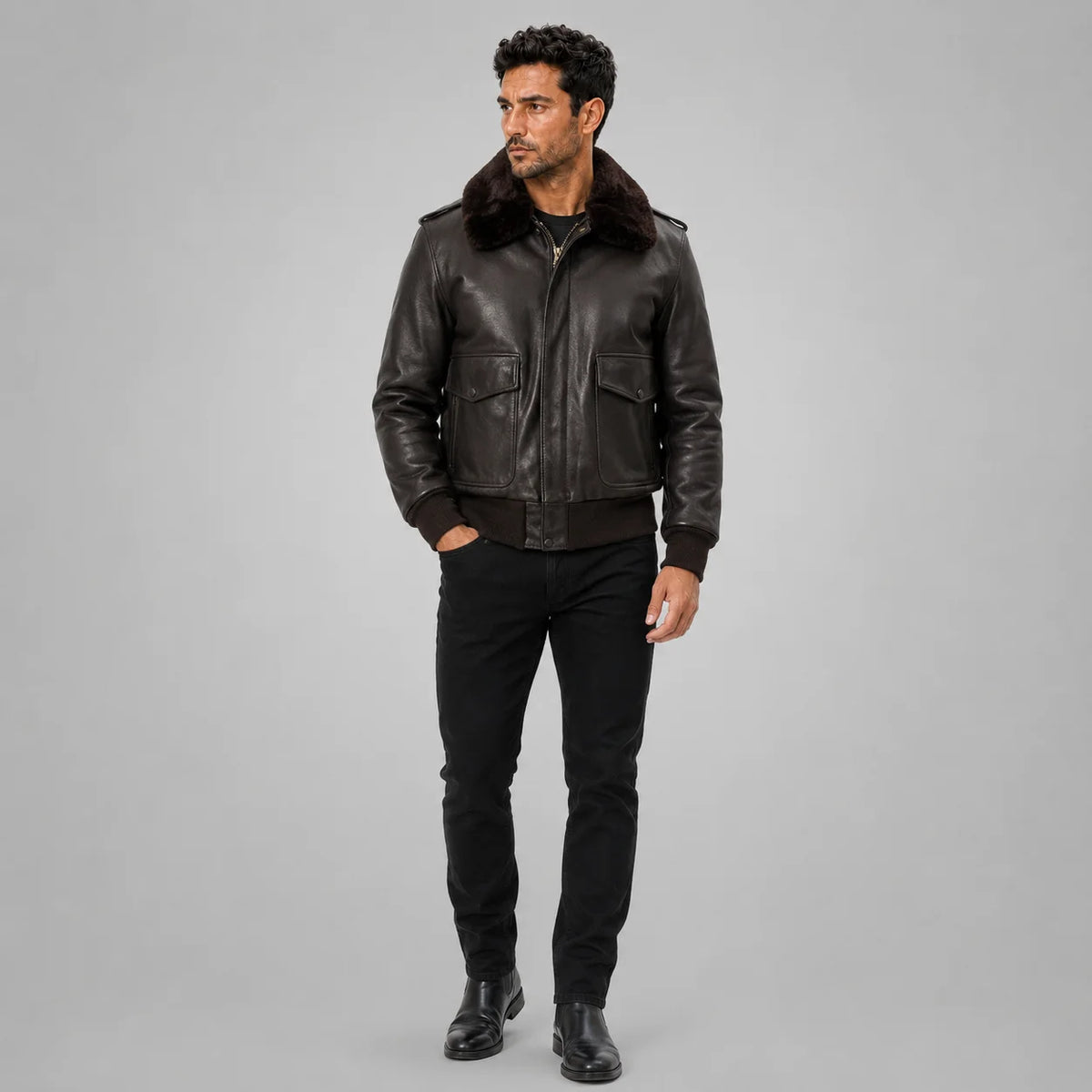 Full-length front styling of men’s brown leather flight bomber jacket with fur collar, flap pockets and black trousers