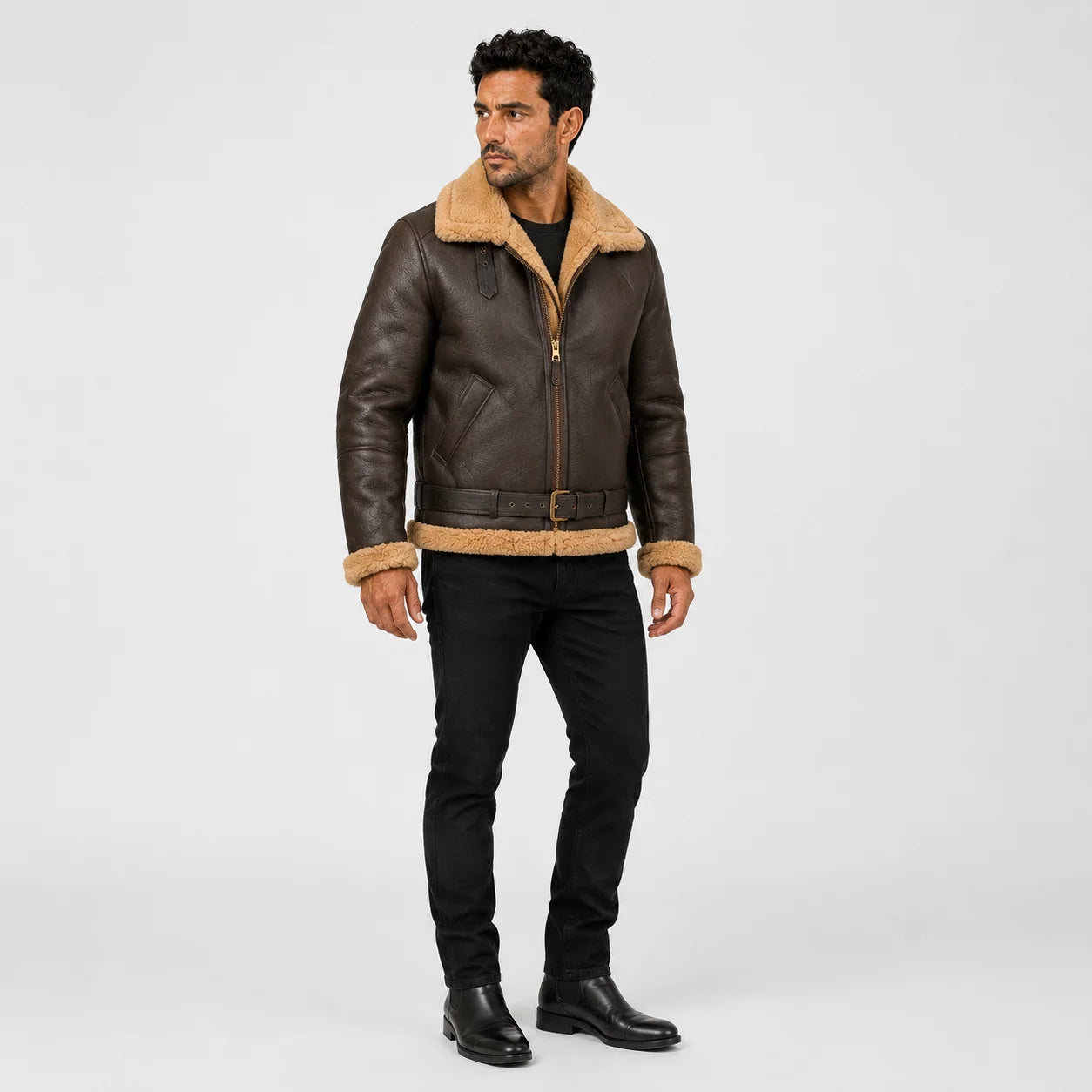 Three-quarter view of men’s brown B3 sheepskin bomber with tan fur collar, angled pockets and buckled waist belt.