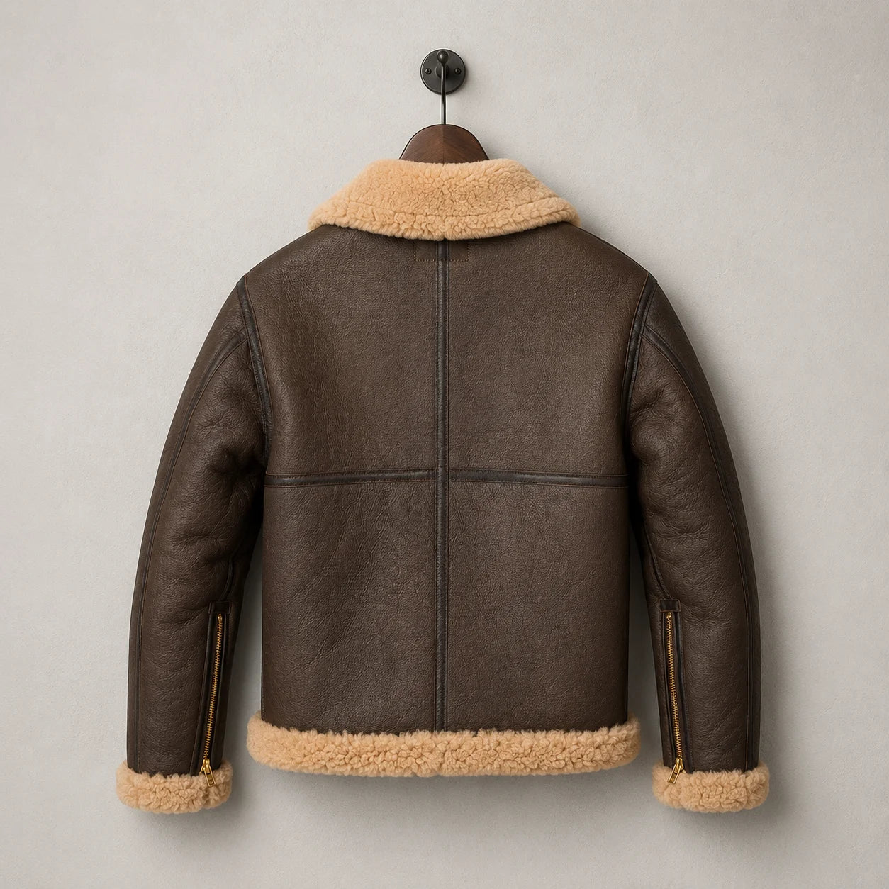 Hanging rear view of brown sheepskin RAF jacket with tan collar and hem, panelled back construction and cuff zipper details.