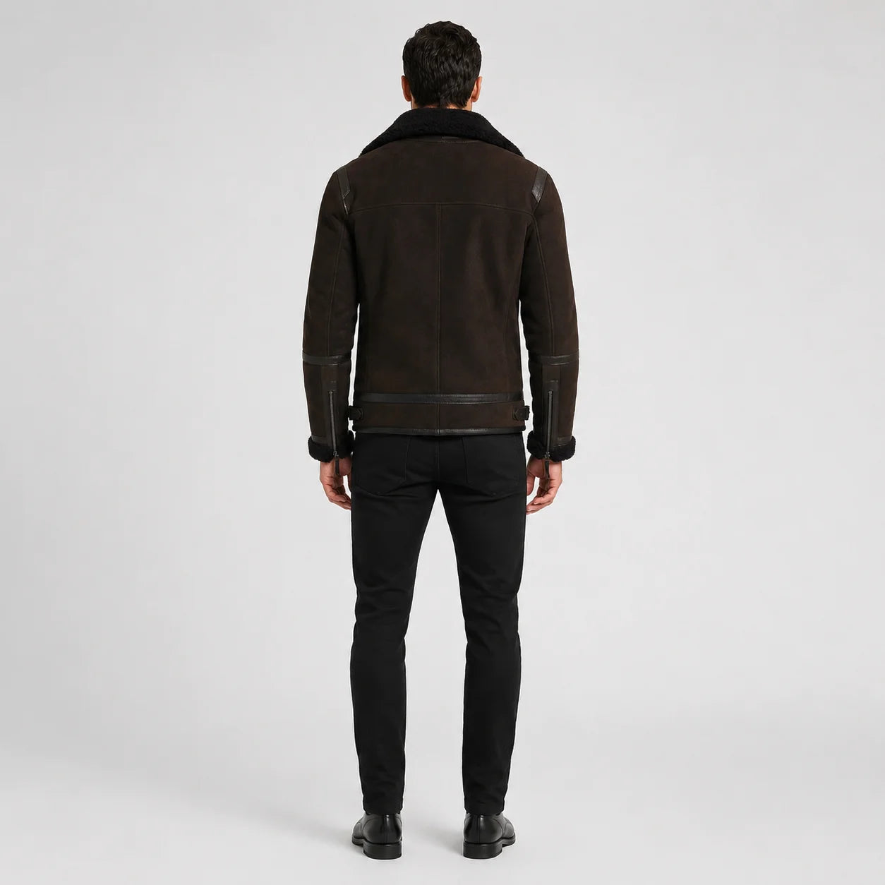 Rear studio view of brown aviator jacket showing clean back yoke, centre seam, waist tabs and cuff zippers