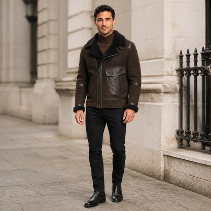 Men wearing a dark brown asymmetric aviator jacket with black trousers in an urban stone-building setting