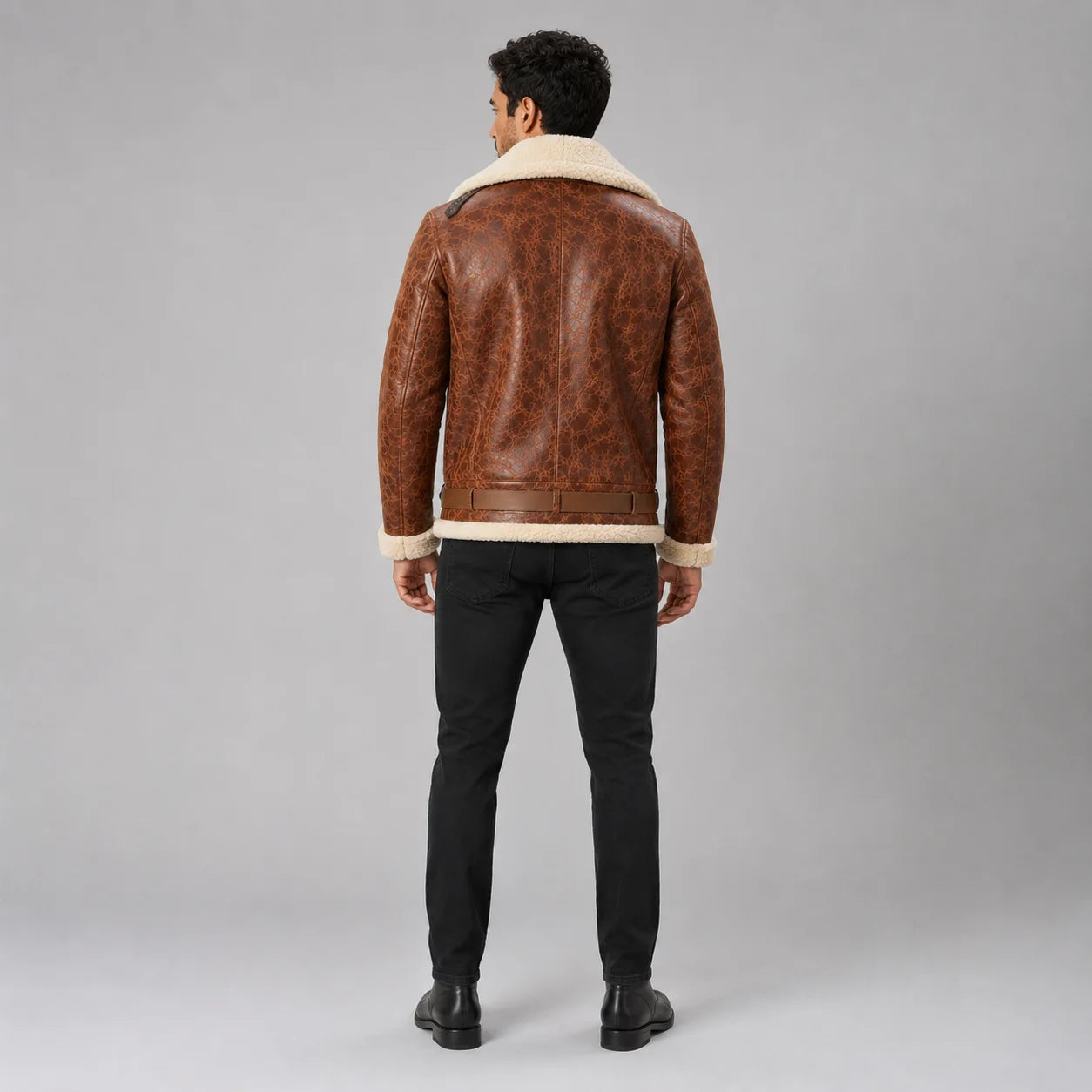 Rear studio view of brown aviator leather jacket showing cream collar and hem, centre construction and waist adjusters