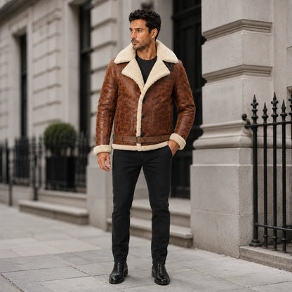 Outdoor lifestyle view of man in brown belted aviator jacket with cream shearling trim, black jeans and boots