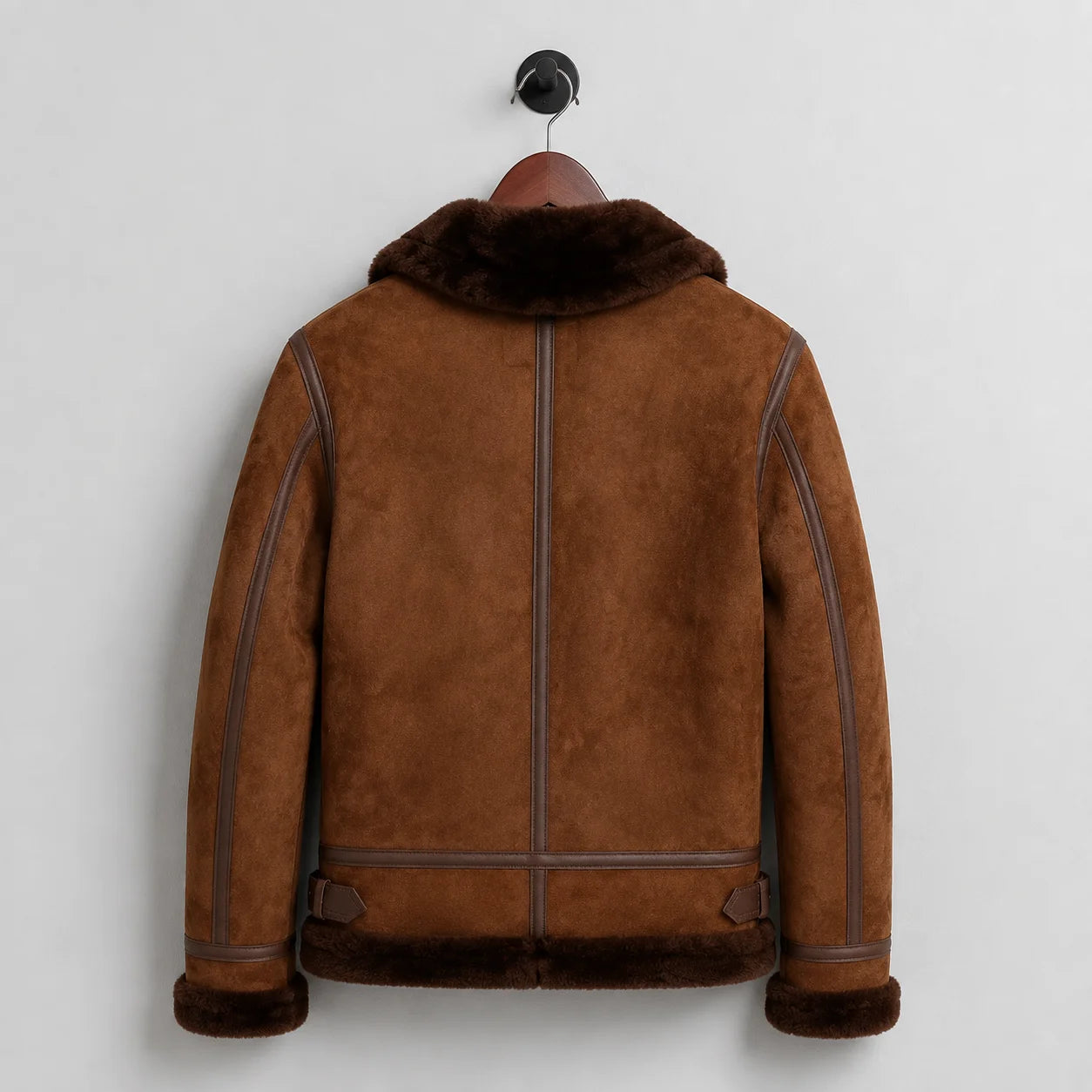 Back hanging view showing brown suede aviator jacket, central seam, contrast piping and dark shearling waistband
