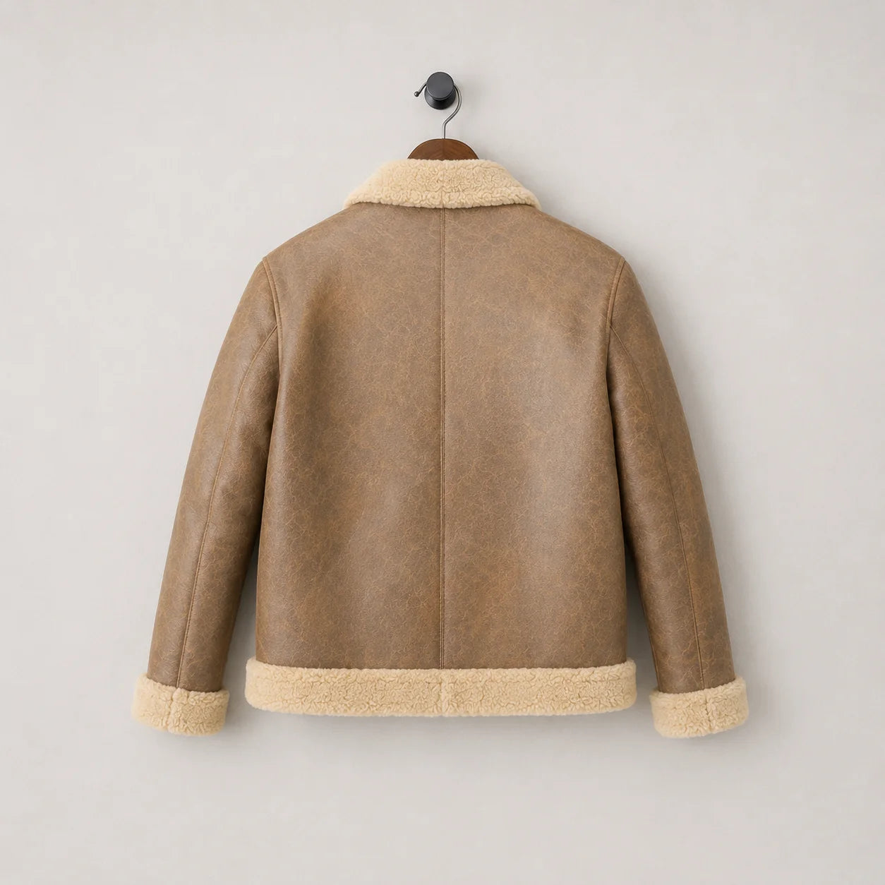 Hanging rear view of camel B3 sheepskin jacket with simple centre back seam, cream collar, cuffs and waistband trim