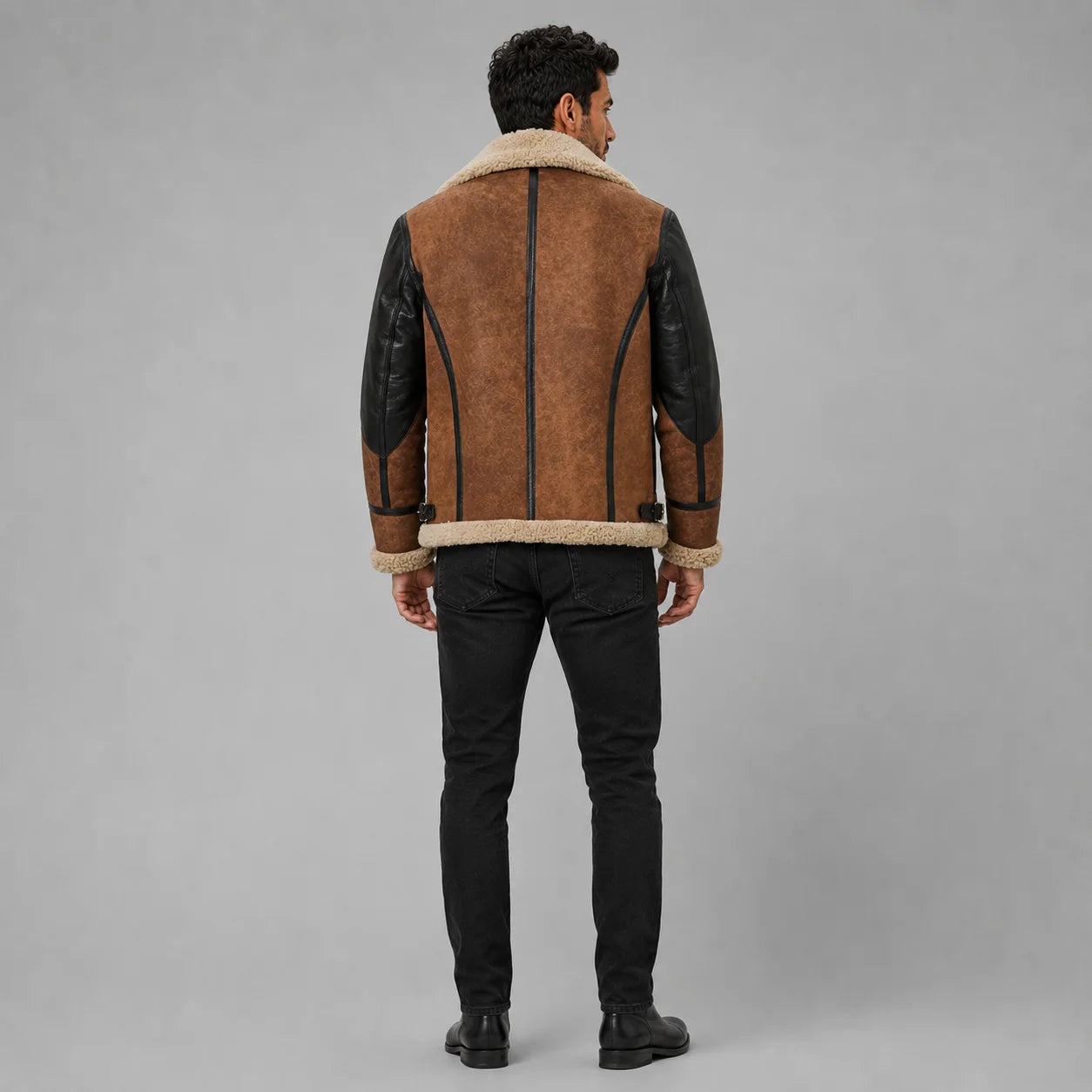 Back view of men’s brown suede B3 aviator jacket showing cream shearling trim, black sleeve panels and curved back seams