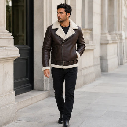 Outdoor lifestyle view of a man wearing a dark brown B3 aviator jacket with cream shearling trim and black trousers.
