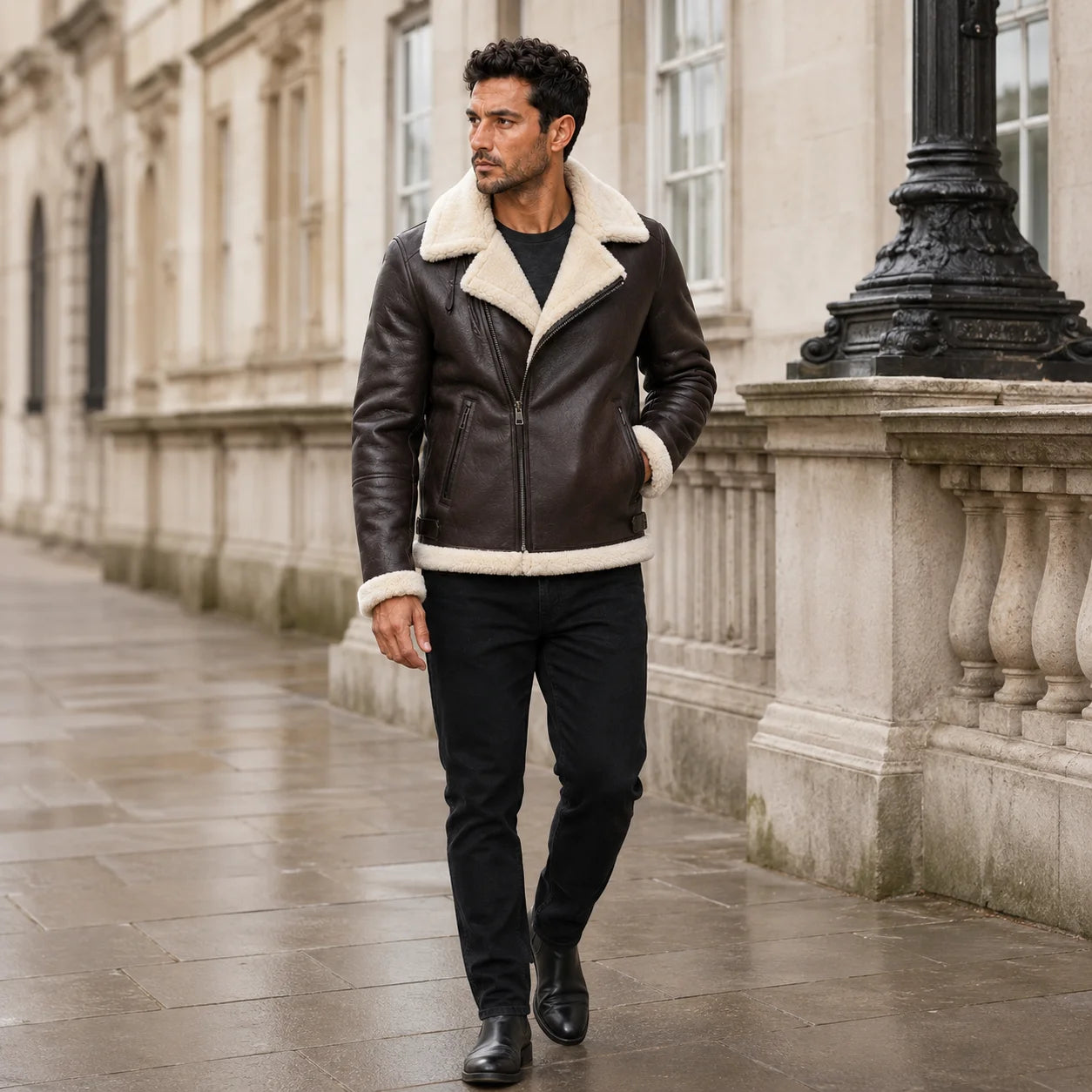 Street-style walking view of men’s brown sheepskin aviator jacket with cream collar, cuffs and short bomber silhouette.