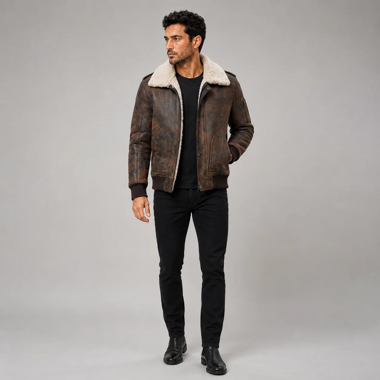 Full-length studio view of men’s distressed dark brown aviator jacket with cream shearling collar and ribbed hem