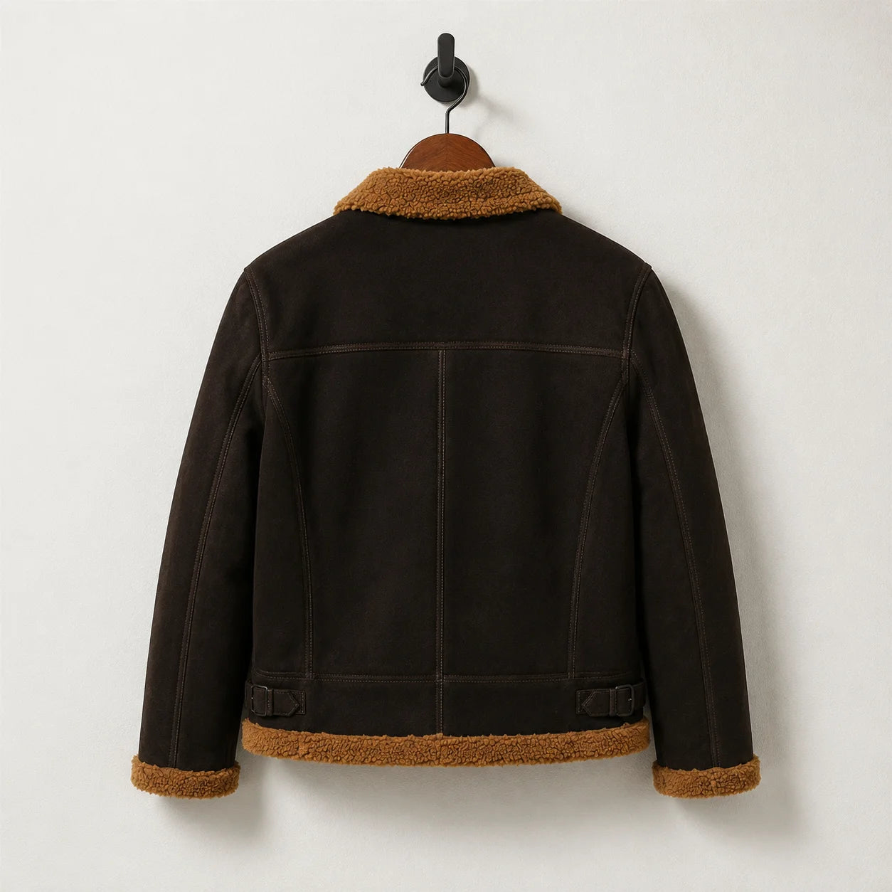 Hanging back view of dark brown aviator jacket with tan collar and hem, structured yoke and vertical back panels