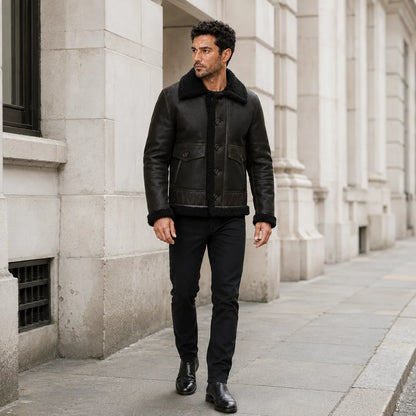Outdoor lifestyle view of men’s dark green aviator jacket styled with black jeans and black leather boots