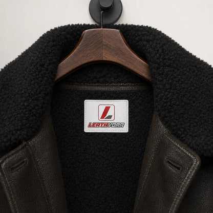 Close-up of black plush collar and lining on dark green aviator jacket with stitched Leathvora neck branding