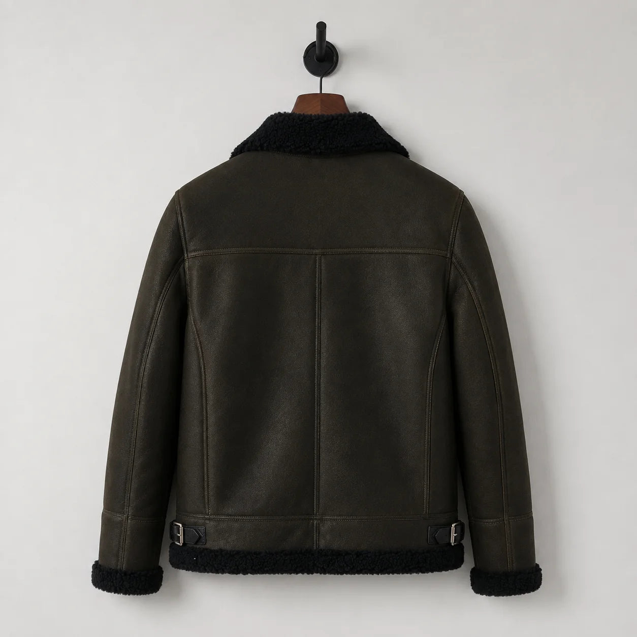 Hanging rear view of green aviator jacket showing black collar and hem trim, back panel seams and side buckle tabs