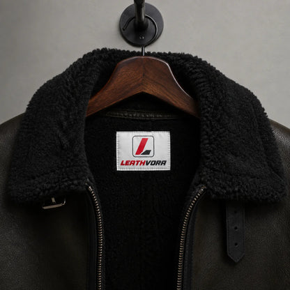 Close-up of black plush aviator collar and lining with Leathvora neck label, zipper and adjustable collar strap