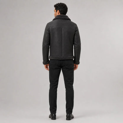 Rear studio view of charcoal aviator jacket showing shoulder yoke, centre seam and dark plush collar and hem