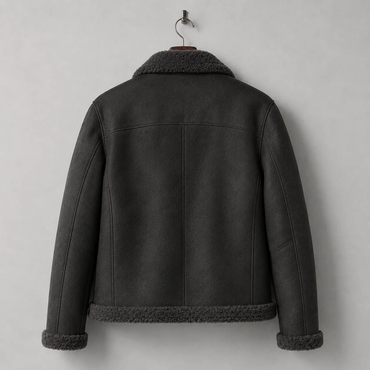 Hanging rear view of dark grey flight jacket with clean shoulder yoke, centre-back seam and plush hem trim